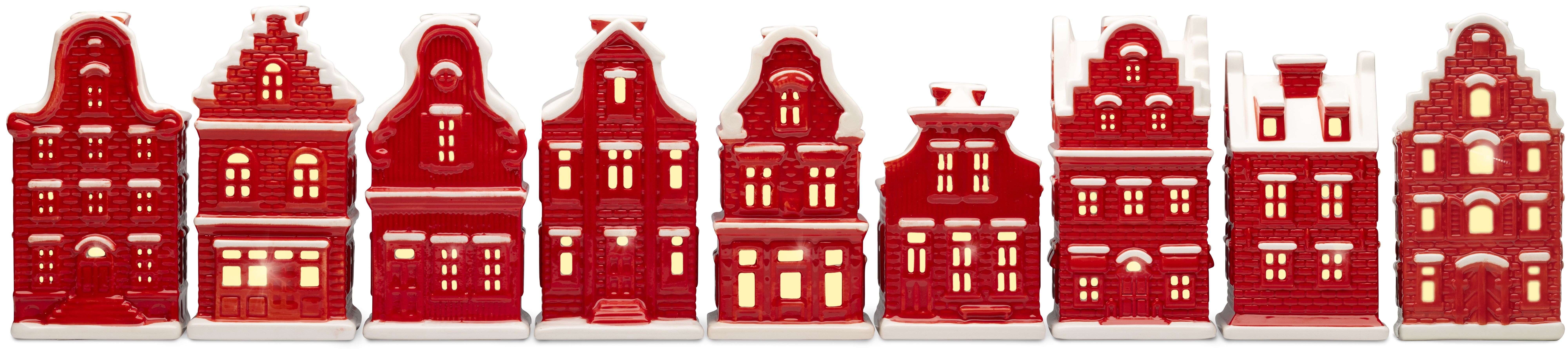 Negen rode huizen van keramiek op een rij, elk met eigen details in de bouw en ramen die verlicht zijn.